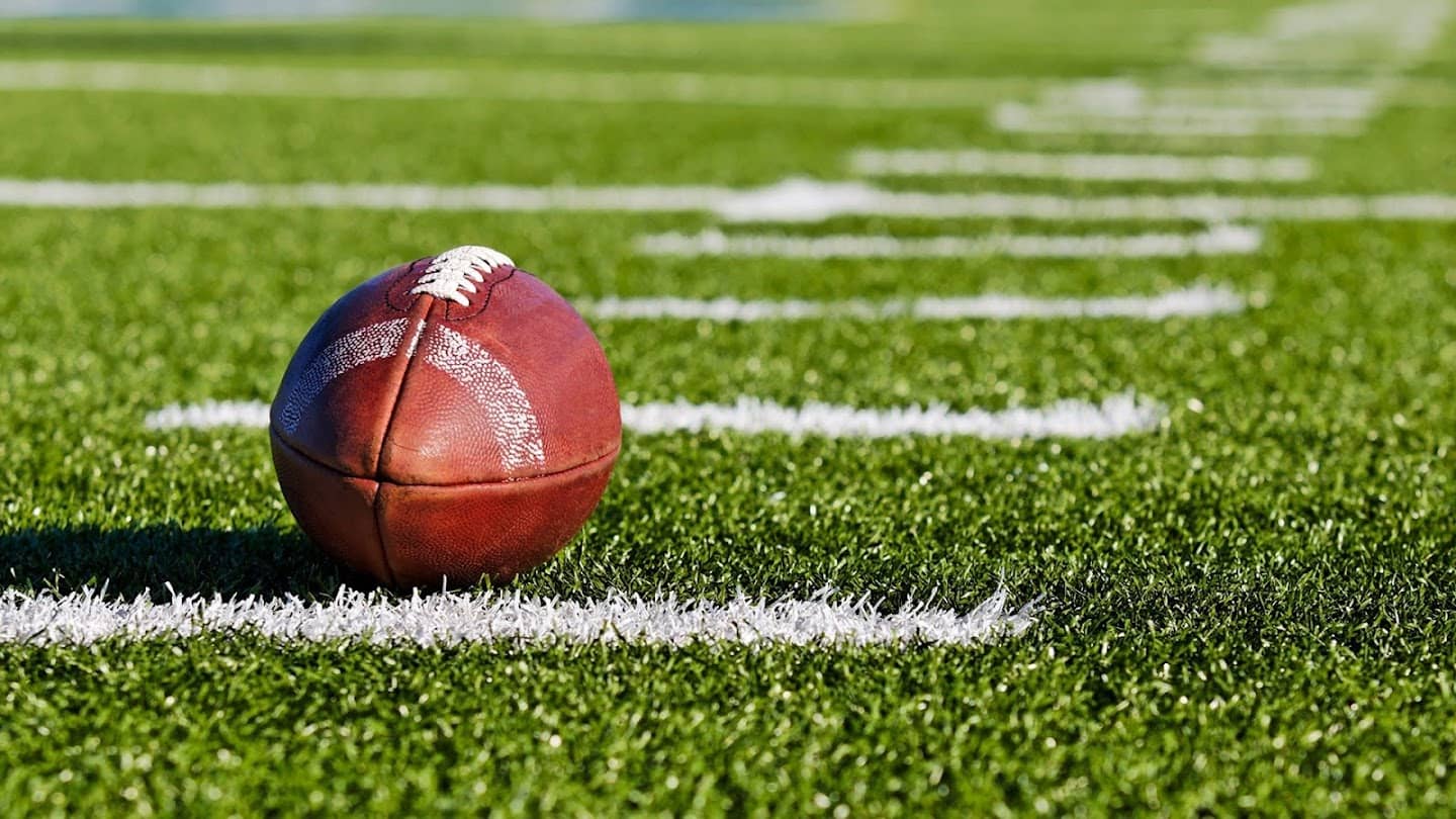 College Football in a field next to hash mark.